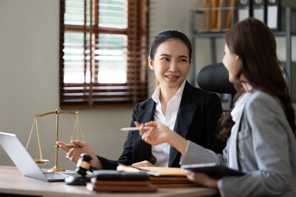 Lawyer office. Statue of Justice with scales and lawyer working on a laptop. Legal law, advice and j