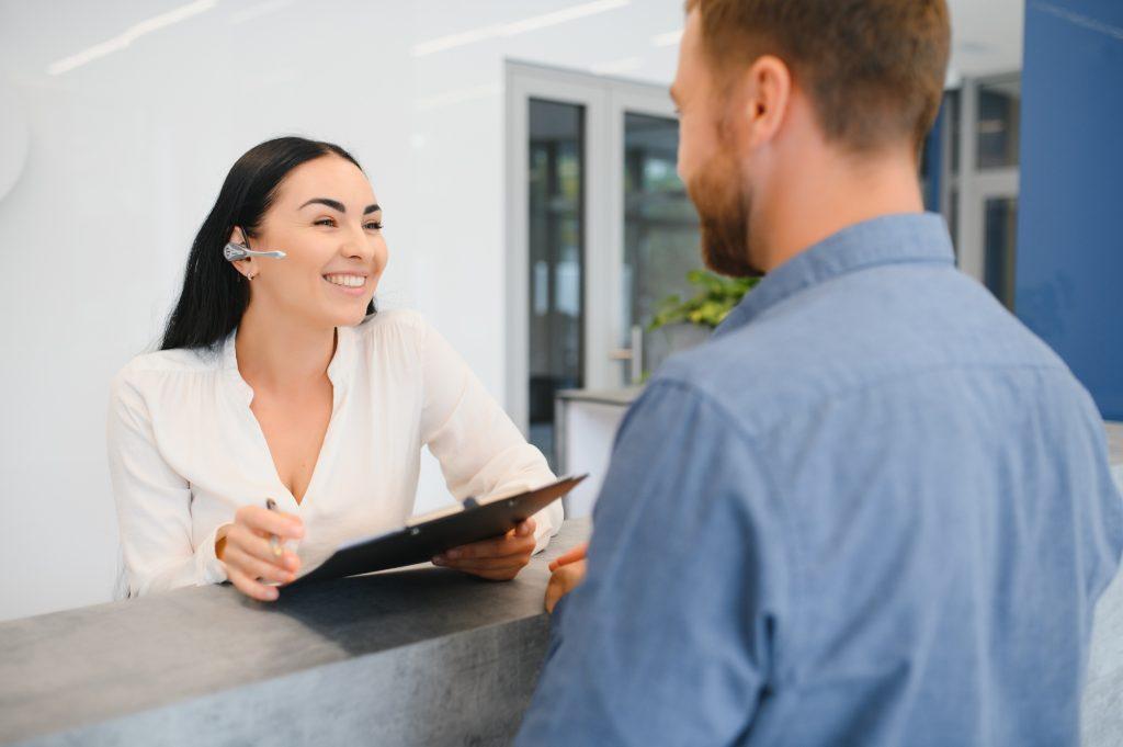 The employee of the beauty salon meets the client in the reception of a modern beauty salon.